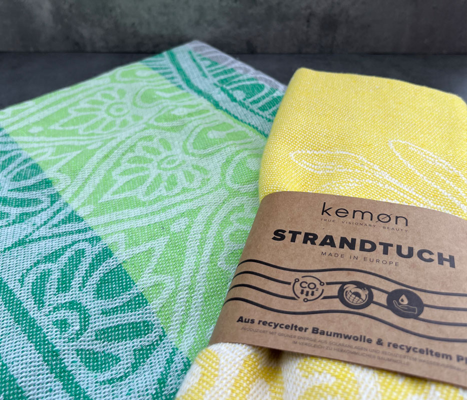 Gemusterte Strandtücher, eines mit bedruckter Banderole